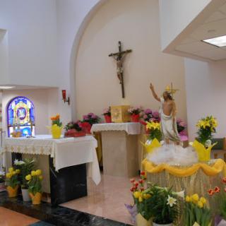 A serene view of a decorated church altar, adorned with flowers and a cross, creating a peaceful atmosphere for worship.