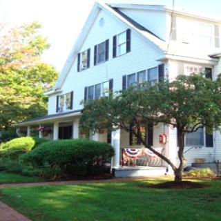 A charming residential house with a well-maintained garden and inviting porch.