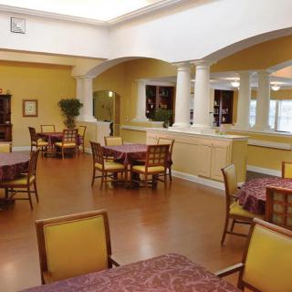 A well-lit dining area with several tables and chairs arranged neatly.