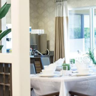 A beautifully arranged dining room featuring a modern table setting and abundant natural light.