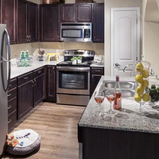 A modern kitchen with stainless steel appliances and granite countertops.