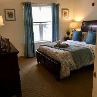A cozy bedroom with a neatly made bed and blue accents.