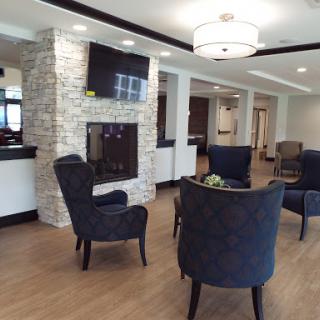 A modern lobby seating area featuring stylish chairs and a cozy fireplace.