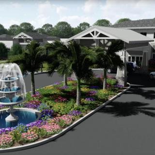 A beautifully landscaped building entrance featuring a large fountain and vibrant garden.