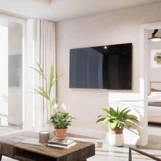A modern, minimalist living room with a wall-mounted TV and lush green plants.