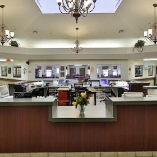 A modern office reception area featuring a clean and well-lit workspace with stylish furniture and decorative lighting.
