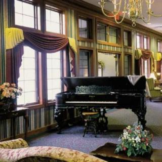 A luxurious living room featuring a grand piano and elegant decor.