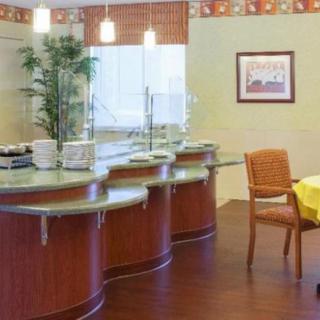 A modern dining area with a curved counter, chairs, and tables.