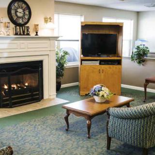 A cozy living room with a fireplace, television, and comfortable seating.