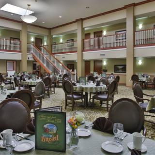 An elegantly set dining area with round tables and chairs, ready for guests.