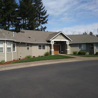 A suburban house with a well-maintained front yard under a clear sky.