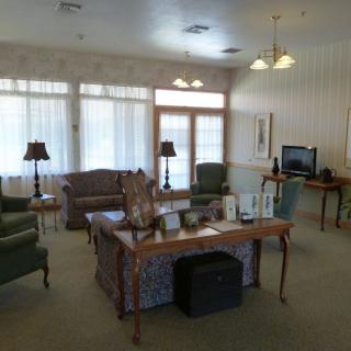 A cozy living room with a sofa, chairs, and a television.