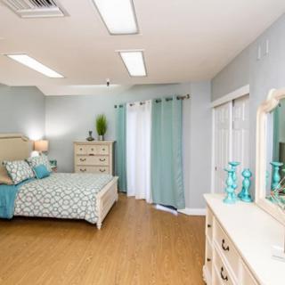 A modern bedroom with stylish decor and light pastel colors.