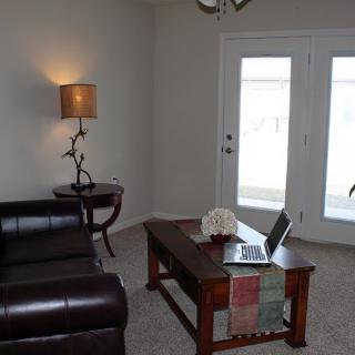 A cozy living room with a sofa, coffee table, and lamp.