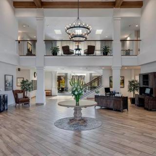 A spacious and elegantly decorated lobby with a large chandelier and modern furnishings.