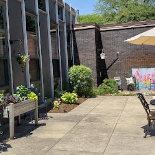 A serene outdoor patio space featuring greenery and seating, perfect for relaxation.