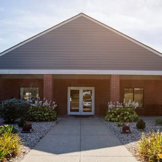 A welcoming entrance to a well-maintained building surrounded by vibrant landscaping.