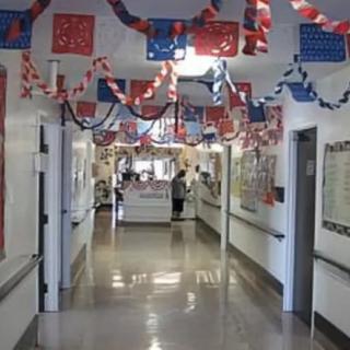 A decorated hospital hallway with patriotic red, white, and blue banners hanging from the ceiling.