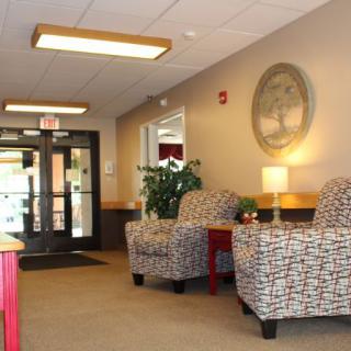 A cozy lobby with patterned chairs, a lamp, and decorative elements.