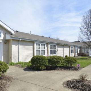 A row of suburban residential homes with well-maintained landscaping and a clear sky.