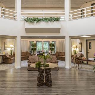 A spacious and elegantly decorated lobby area with comfortable seating and greenery.
