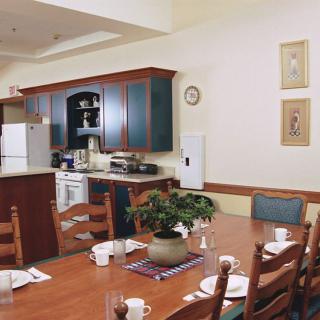 A cozy kitchen and dining area with wooden furniture and a decorative plant centerpiece.