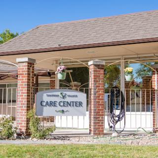 A welcoming view of a care center, featuring a sign and well-maintained surroundings.