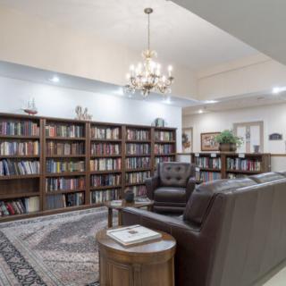 A cozy library with bookshelves and a comfortable seating area.