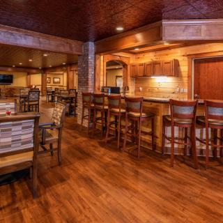 A cozy restaurant interior featuring a wooden bar and seating area.
