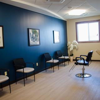A modern, minimalist waiting room with a blue accent wall and seating.