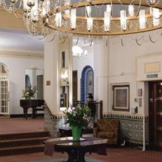 Elegant hotel lobby featuring a grand chandelier and classic furnishings.