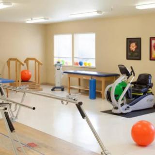 A rehabilitation room equipped with various exercise and therapy equipment.