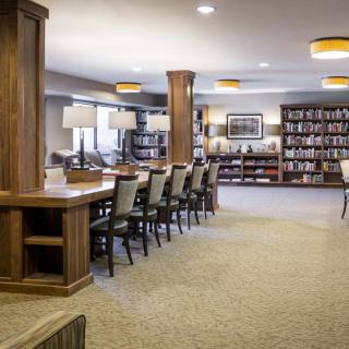 A spacious library interior with rows of bookshelves and tables for reading.