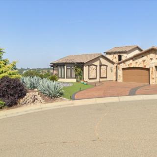 A suburban house with a landscaped front yard and spacious driveway.
