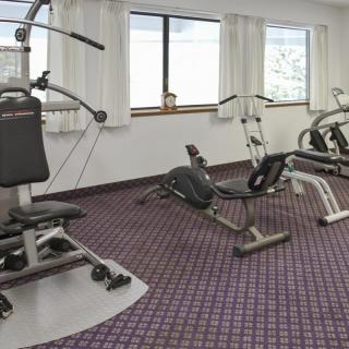 A small gym room with various exercise machines and equipment.