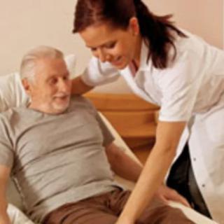 A nurse assists an elderly patient while they are sitting on a bed.