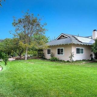 A suburban house with a lush green yard and clear blue sky.