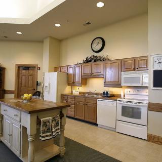 A modern kitchen with wood cabinets, an island counter, and various appliances.