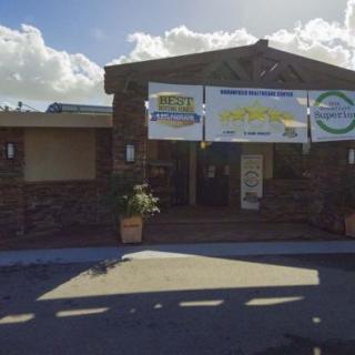 A building entrance with banners and signage under a clear sky.