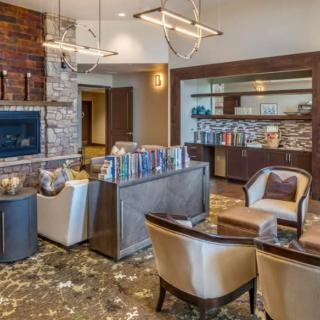 A modern living room with a cozy seating arrangement, fireplace, and contemporary lighting.