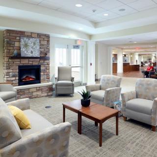A cozy living room with modern furniture, featuring a fireplace and comfortable seating.