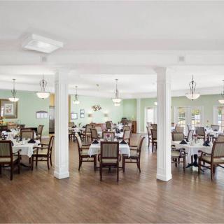 A spacious and elegantly decorated dining room with multiple tables set for guests.