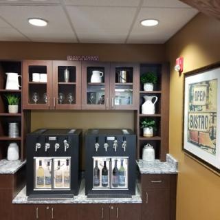 A well-equipped coffee station featuring two self-serve beverage machines and neatly arranged cabinets.