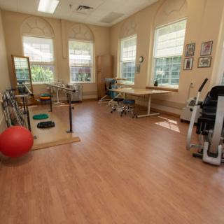 A bright and spacious physical therapy room equipped with various exercise tools.