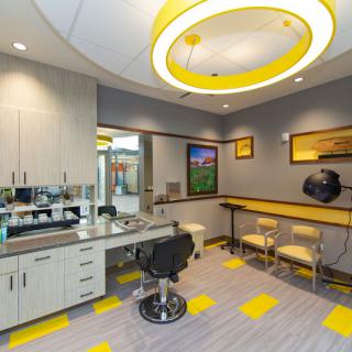 A modern dentist office with bright lighting and yellow accents.