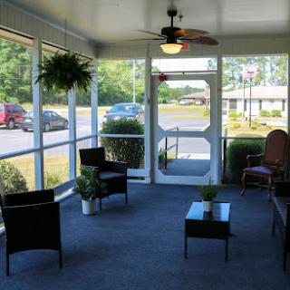 A cozy indoor porch with seating and plants, perfect for relaxation.