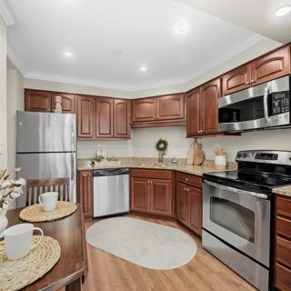 A modern kitchen with wood cabinets and stainless steel appliances.