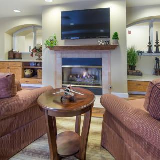 A cozy living room featuring a fireplace, television, and comfortable seating.