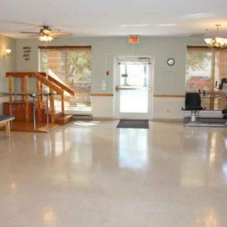 A spacious rehabilitation room equipped with exercise equipment and therapy stations.
