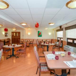 A cozy dining room with neatly arranged tables and chairs, adorned with decorative elements.